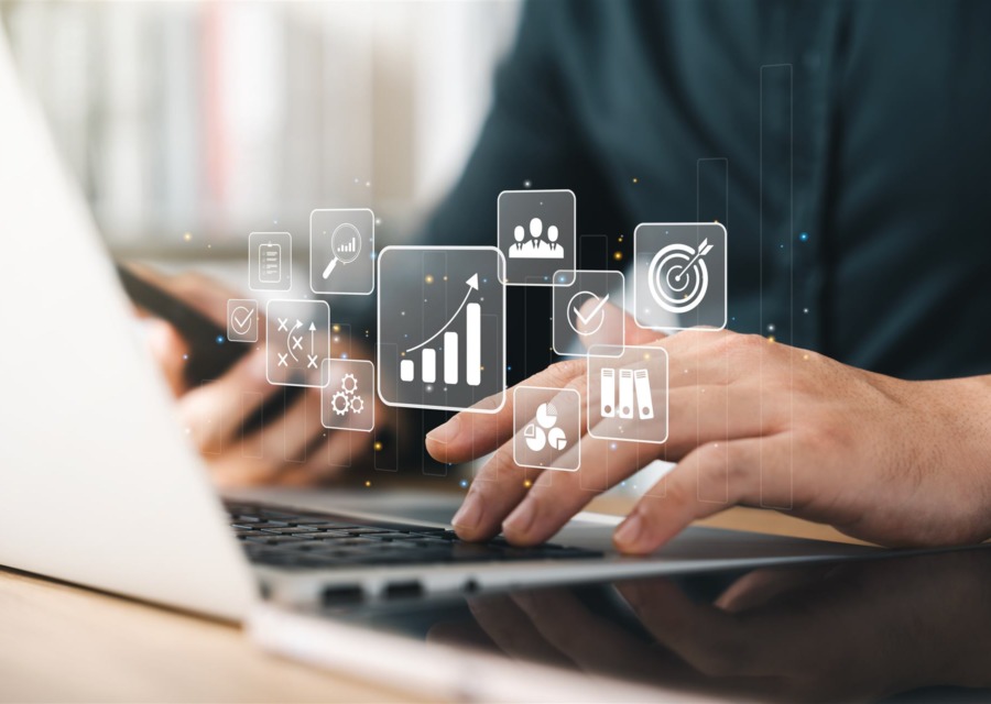 Mãos digitando em notebook com ícones de marketing e crescimento