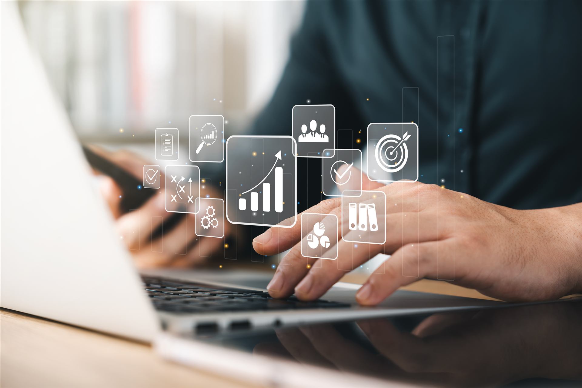 Mãos digitando em notebook com ícones de marketing e crescimento